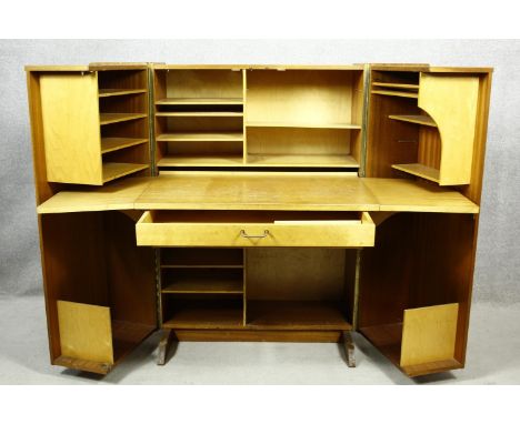 A mid century vintage teak Newcraft &amp; Co. office in a box, fitted cabinet with doors opening to reveal fully fitted offic