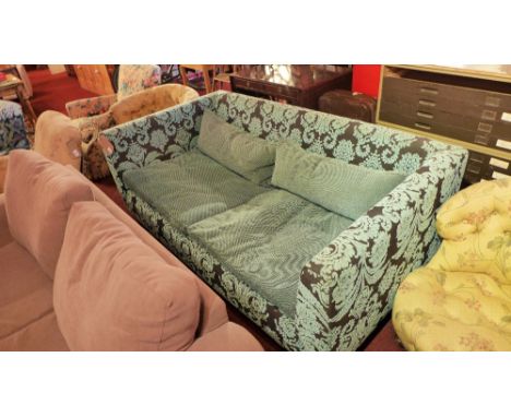 A contemporary designer two seater sofa upholstered in blue foliate patterned fabric