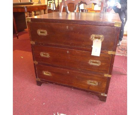 A Victorian mahogany and brass bound campaign chest of three long drawers raised on bracket supports 