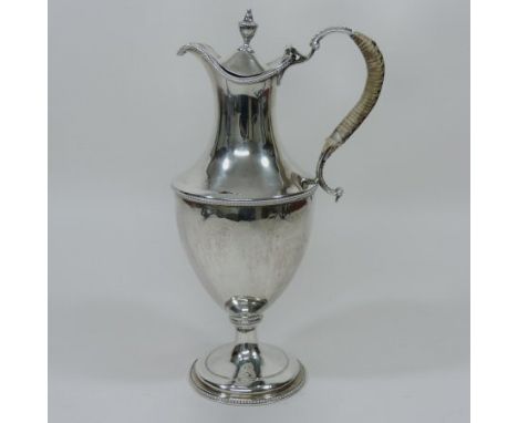 A Victorian silver claret jug, of Neoclassical pedestal shape, with a hinged lid and rattan bound scrolled handle, with beade