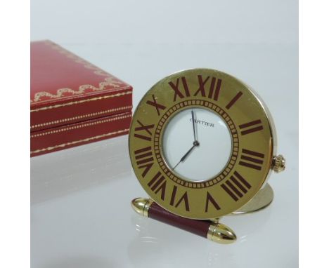 A Must de Cartier folding travel clock, with a gilded case and quartz movement, numbered 891103214, in original box, with pap