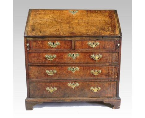 A George II burr elm bureau, with a fitted interior, enclosed by a hinged sloping fall, on bracket feet, 94cm