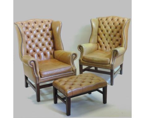 A pair of brown leather upholstered button back wing armchairs, together with a matching footstool