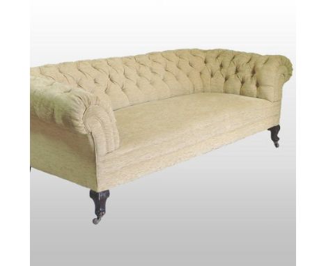 A Victorian cream upholstered button back chesterfield sofa, on carved legs and castors, 216cm