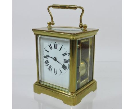 A French brass cased carriage clock, the white enamel dial with Roman hours, 12cm tall