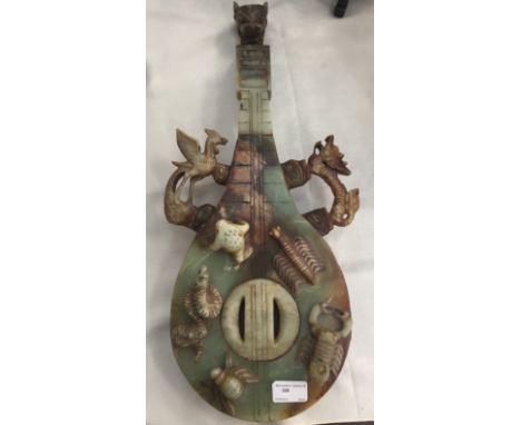 A carved soapstone instrument with dragon head finial, ho-ho bird and dragons in high relief; together with five carved anima