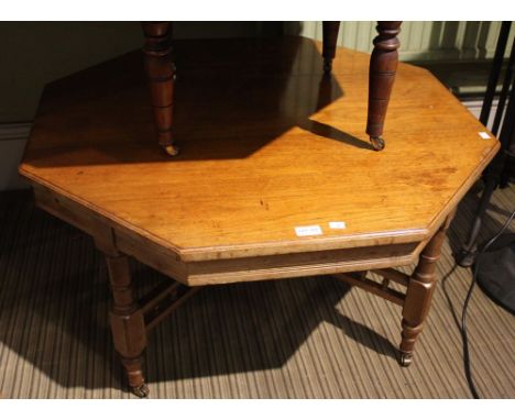 A mahogany octagonal occasional/coffee table on turned supports with castors, bobbin turned stretcher