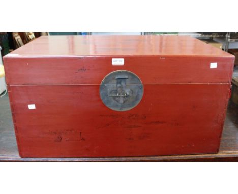 An Oriental red lacquer trunk with fitted carrying handles 78 cm wide