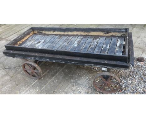 A vintage railway luggage trailer, with painted wooden decking to cast iron wheels, 217 x  91cm. This was used for many years