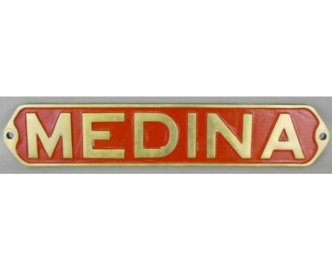 A reproduction brass and red enamel nameplate 'Medina', 55 x 11 cm.