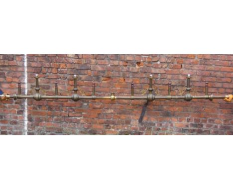 A large brass light fitting, length approximately 390cm.