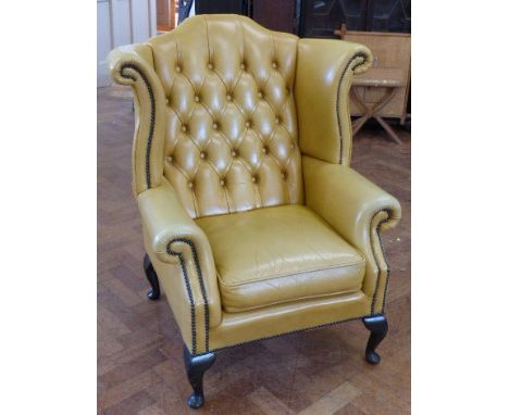 Light tan leather wing-back chair on cabriole legs.