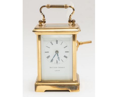 Matthew Norman of London - A small carriage clock, Swiss made, with carry handle to top and outer brass casing, with accompan