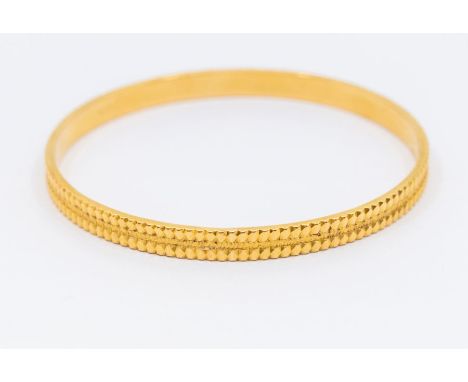 An 18ct gold bangle, textured finish, width approx 6mm, internal diameter approx 63mm, stamped 750, weight approx 30gms Furth