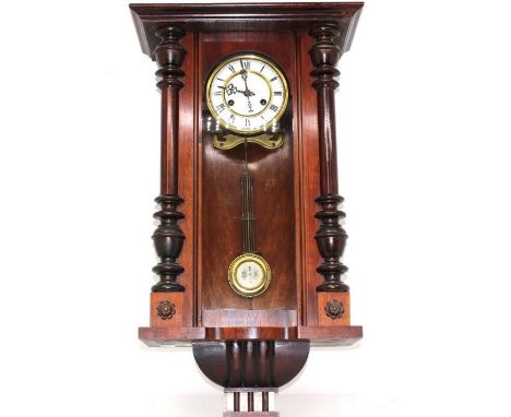 A wooden cased Vienna wall clock with pendulum and key inside.