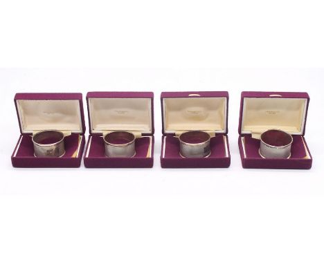 Four Modern engine turned silver napkin rings of circular form, all in purple cases, all hallmarked Birmingham, 1976, Broadwa
