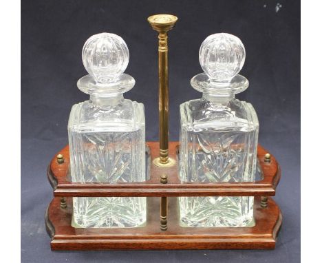 A mid 20th Century mahogany two decanter tantalus, with brass carrying pole