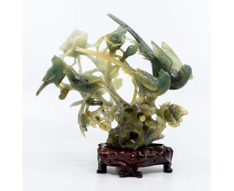 A Chinese cloudy shaded green jade figural group of four birds amongst roses, 16cm high, with hardwood base, boxed&nbsp;