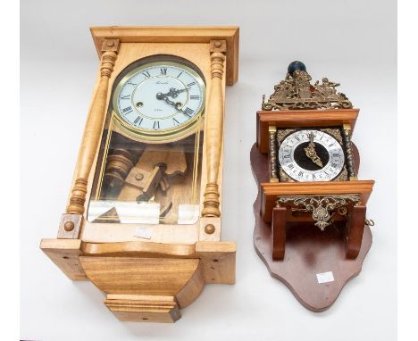A modern Lincoln 31 day wall clock in wooden case, with a dark wooden with cast model of Atlas to top.