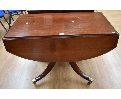 A mahogany breakfast table on brass castors along with an Edwardian glazed display cabinet on spear legs (cracked glass)