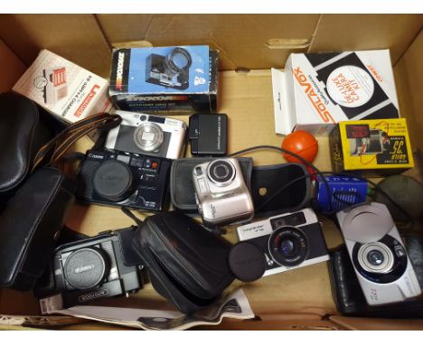 A Canon Z70w camera, a Konica camera, a Nikon Cooldix 3100 camera, a Canon AF35M camera, a Voigtlander BF 135 camera, and var
