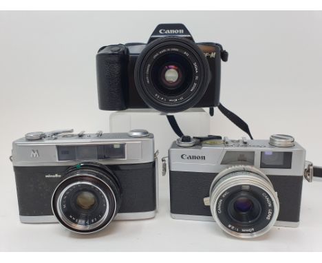 A Minolta M camera, a Canon Canonet 28 camera, and a Canon EF-M camera, with travel case (3)Provenance:  Part of a vast singl