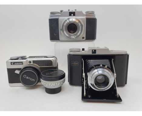 An Adox folding camera, an Agfa camera, with leather outer case, and a Canon Demi camera, with leather outer case and lens (3