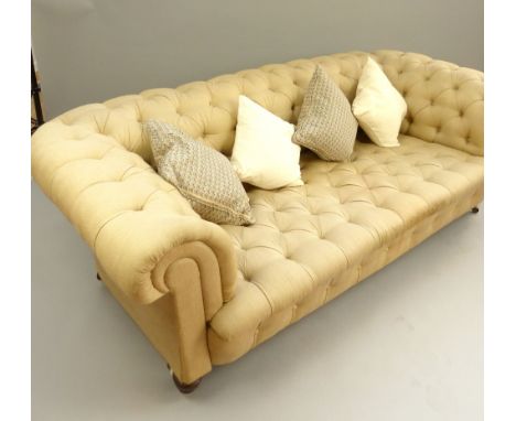 Chesterfield sofa, triple seat, buttonback roll arms, turned legs and brass castors, c 1890, contemporary neutral upholstery,