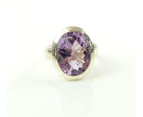 Amethyst dress ring, the oval cut stone collet set in a white metal band stamped 925, 17.6g