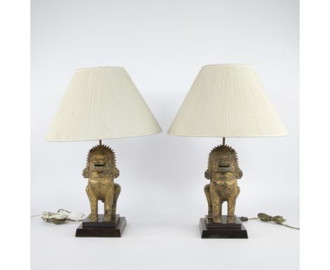 Pair of table lamps in the shape of gilded Asian-style temple guardians (foo dogs or shishi) , placed on wooden bases and fit