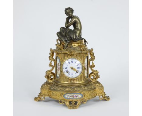French Louis XVI style mantel clock made of richly decorated gilt bronze, surmounted by a bronze figure of a seated nymph and