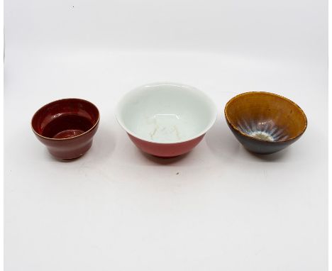 A Chinese porcelain bowl, bright red glaze, top rim with off-white which continues into the centre of bowl, glazed step foot 