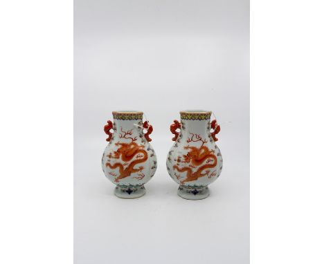 A pair of Chinese polychrome enamel porcelain vases, decorated with an iron red dragon chasing the flaming pearl, with gilt h