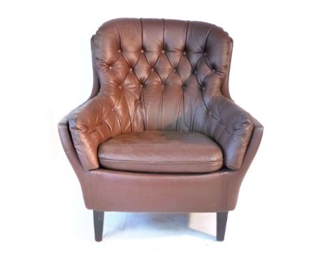 A brown button upholstered lounge armchair on mahogany straight tapering feet