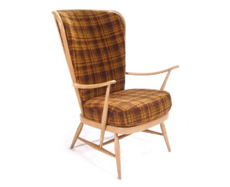 An Ercol beech and upholstered highback lounge armchair on tapering legs. CONDITION REPORT: heavy wear, cracks to arms. joint