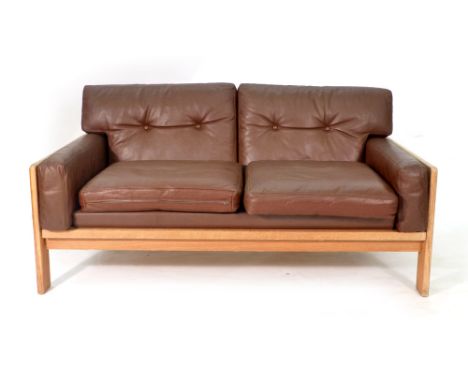 A 1970's brown leather and button upholstered two seater sofa with a square oak frame CONDITION REPORT: No bolts for one end.