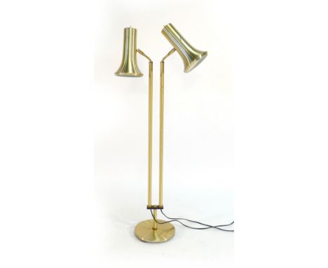 A 1970's brass coloured twin spot adjustable standard lamp CONDITION REPORT: pitting and kocks to frame, working order unknow