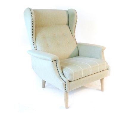 A pair of 1960's high and lowback armchairs with button upholstery on beech tapering feet