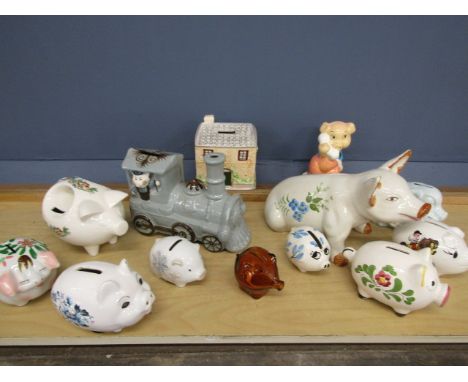 A quantity of ceramic pig money boxes plus a house