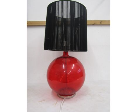 A large red glass based lamp with shade&nbsp;