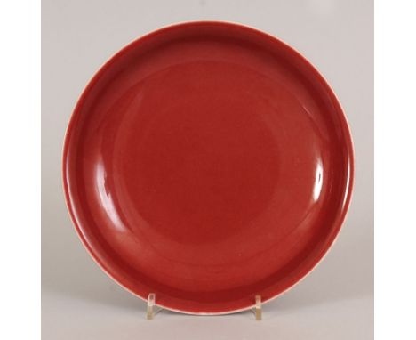 A CHINESE COPPER RED PORCELAIN SAUCER DISH, the base with a Qianlong seal mark, 7.25in diameter.