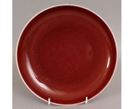 A CHINESE COPPER RED PORCELAIN DISH, of saucer shape, the base with a Qianlong seal mark, 9.1in diameter.