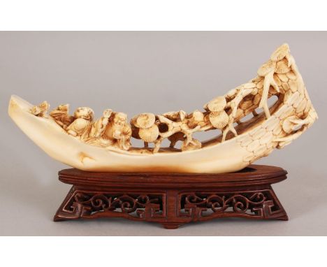 AN EARLY 20TH CENTURY CHINESE CARVED IVORY MODEL OF A RIVER BOAT, together with a fitted carved and pierced wood stand, the b