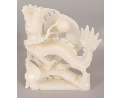A 20TH CENTURY CHINESE WHITE HARDSTONE STYLE MODEL OF A DRAGON, 10.25in wide at widest point & 11.5in high.