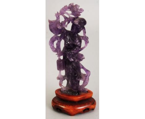 ANOTHER CHINESE AMETHYST FIGURE OF GUANYIN, together with a fixed wood stand, the Goddess holding a lantern, 6.5in high overa