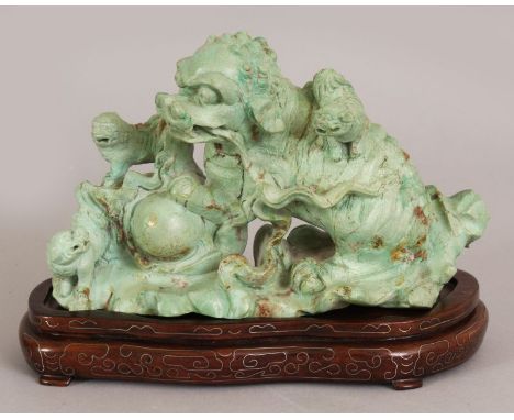 AN EARLY 20TH CENTURY CHINESE LIGHT GREEN CARVED HARDSTONE MODEL OF A BUDDHISTIC LION & PUPS, together with a fitted silver-w