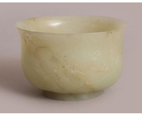 A 16TH CENTURY CHINESE MING DYNASTY CELADON GREEN JADE BOWL, with everted rim, the sides carved in shallow relief with meande