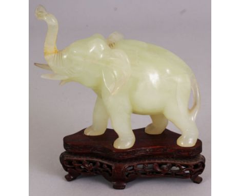 A CHINESE PALE CELADON GREEN BOWENITE MODEL OF A STRIDING ELEPHANT, together with a fitted wood stand, 5.2in high overall, th