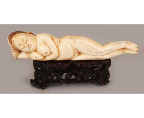 AN EARLY 20TH CENTURY CHINESE IVORY DOCTOR'S MODEL, together with a carved wood stand, the lady in a reclining posture, the i