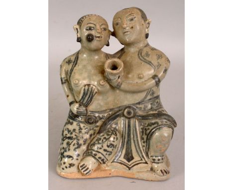 A THAI SAWANKHALOK GLAZED CERAMIC MODEL OF A SEATED COUPLE, their loose robes with floral decoration, the base unglazed, 5.6i